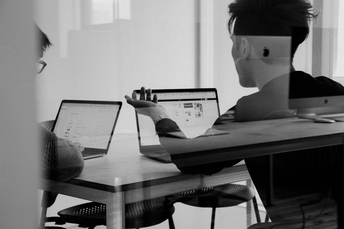 Two people working through a task at their laptops