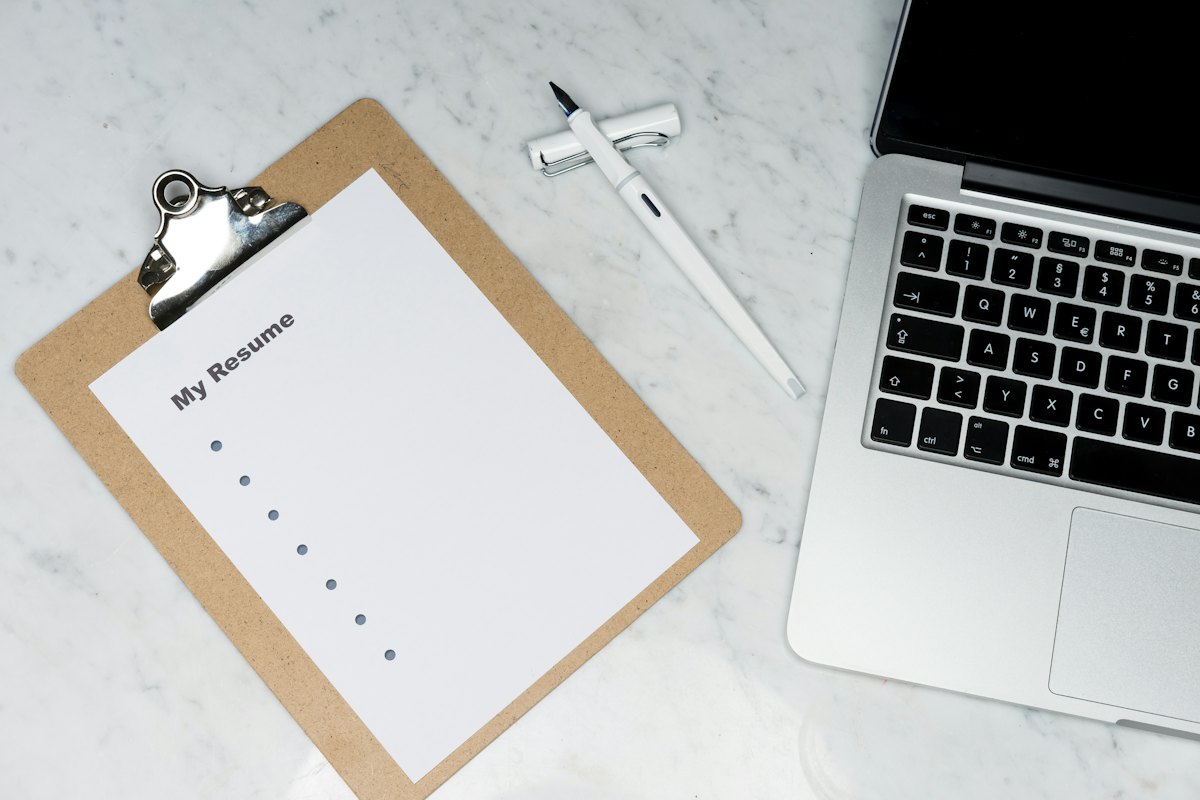 A printed document beside an open laptop