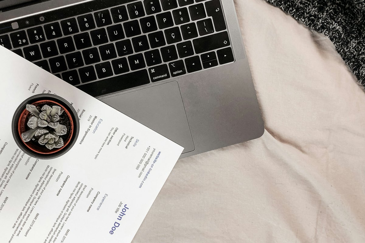 A printed resume resting on a laptop keyboard